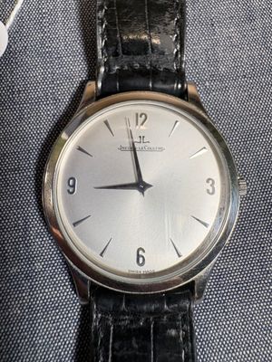 une montre en argent avec un bracelet en cuir noir
