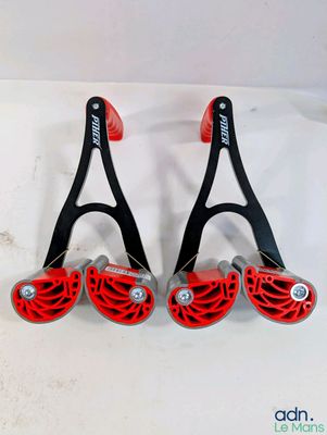 deux paires de raquettes de tennis rouges et noires posées sur une surface blanche
