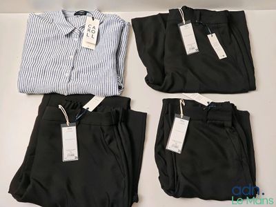 trois pantalons de costume pour homme et une chemise posés sur une table
