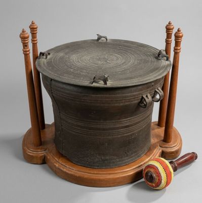 a large metal pot sitting on top of a wooden stand