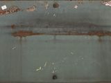 a picture of a rusted metal plate on a wall