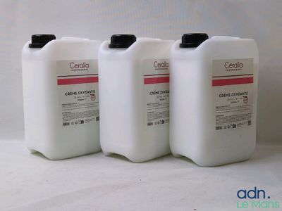 trois gallons de liquide posés les uns à côté des autres sur une surface blanche