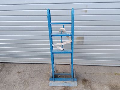 une échelle bleue sur laquelle est posé un rouleau de papier toilette, à côté d'une porte de garage