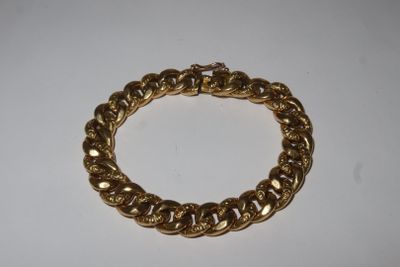 a close up of a gold chain bracelet on a white surface