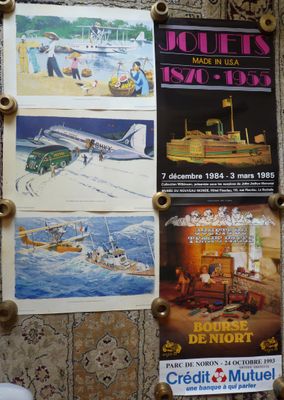 des affiches accrochées au mur au-dessus des toilettes dans la salle de bains