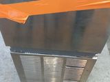 an orange tape wrapped around the bottom of a stainless steel freezer