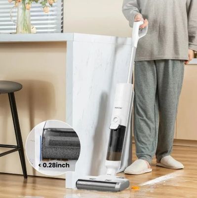 La femme utilise l'aspirateur pour nettoyer le parquet.