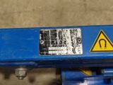 a close up of a blue machine with a warning sign on it