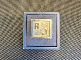 une petite boîte carrée contenant une pièce d'or