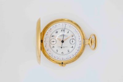 a close up of a gold pocket watch on a white surface
