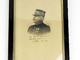 une vieille photo d'un homme en uniforme militaire, dans un cadre noir