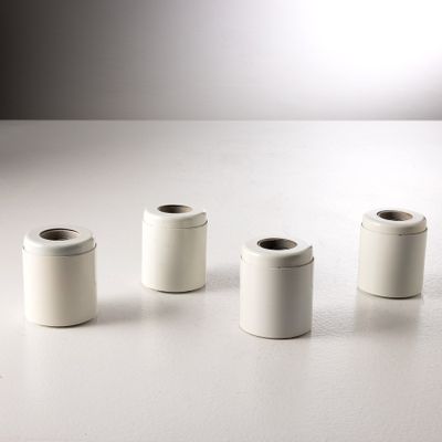 Plusieurs récipients blancs sont alignés sur une surface blanche