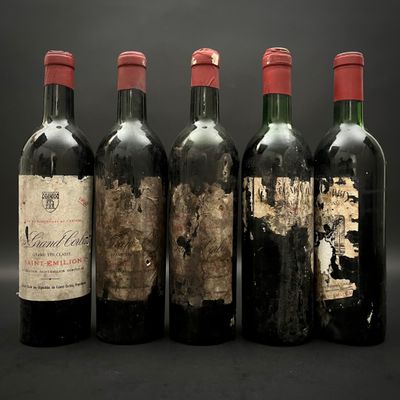 quatre bouteilles de vin sont alignées sur un fond noir