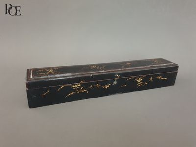 une boîte noire et dorée posée sur une table blanche