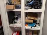 une étagère blanche sur laquelle sont posés tout un tas d'appareils électroniques