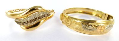 two gold rings with diamonds on them sitting next to each other