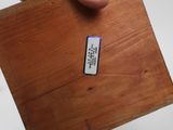a person holding a piece of wood with a label on it