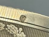 un gros plan d'une montre en argent ornée d'un diamant au centre