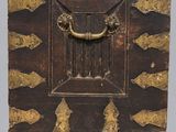 an old wooden box with a brass handle on a gray background