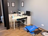 une pièce avec un bureau, une chaise, une imprimante et d'autres objets posés par terre