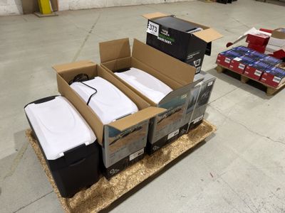 deux cartons de chemises blanches posés sur une palette dans un entrepôt