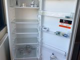 a white refrigerator with its door open in a kitchen