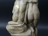 two statues of a man and a woman hugging on top of a toilet