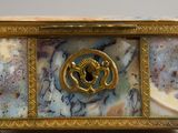 a marble box with a gold decoration on it