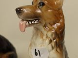 two figurines of dogs sitting next to each other on a table