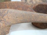 two old rusty tools sitting on a white surface