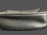 an image of a silver purse on a grey background