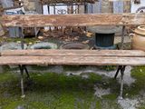 un banc en bois posé devant un bâtiment en pierre