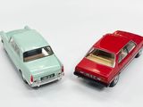 two toy cars sitting next to each other on a white surface
