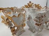 three white and gold vases sitting on a table