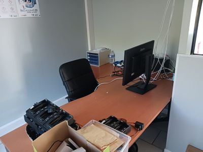 un bureau sur lequel se trouvent un écran d'ordinateur et une pile de boîtes