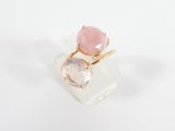 un gros plan d'une bague rose et blanche posée sur une surface blanche