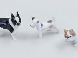 three small figurines of dogs standing next to each other