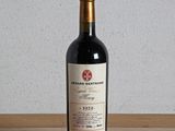 une bouteille de vin rouge posée sur une table en bois