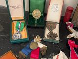 many medals and medals on a table next to a book