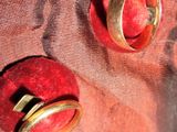 deux anneaux posés sur une pomme rouge, elle-même posée sur un linge