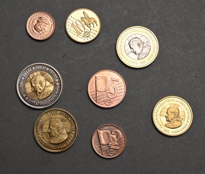 Plusieurs pièces de monnaie différentes sont disposées sur une surface noire.