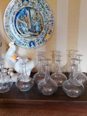 de nombreux vases en verre et une assiette posés sur une table