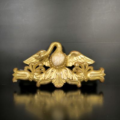 une image représentant une broche en forme d'oiseau en or posée sur un fond noir