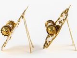 pair of gold and white earrings with a skull on top of them