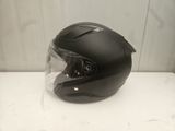 a black helmet on a white table in front of a white wall