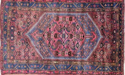 un tapis rose et bleu orné d'un motif en médaillon