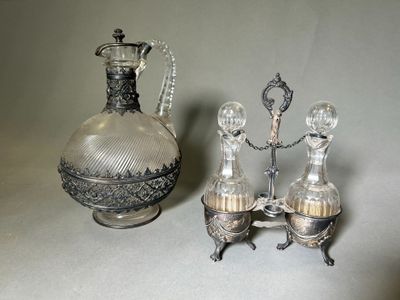 un vase en argent et en verre et une carafe en argent et en verre posés sur une table