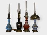 four different colored lamps are lined up on a white surface