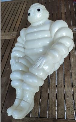a white inflatable statue of a man sitting on a table