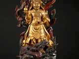 statue of a golden buddha on a black background with a black background